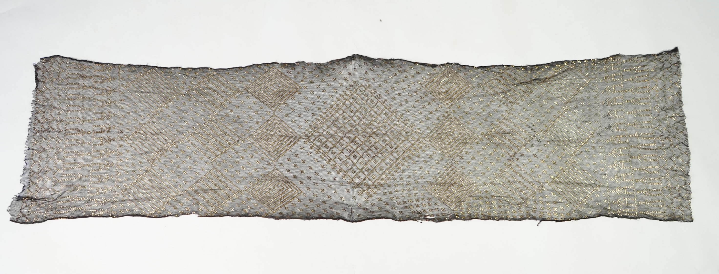 A 1930’s Egyptian decorative metal on black net evening stole. Approximately 218cm long. Condition - the rolled edges are frayed but the colour and design are intact.